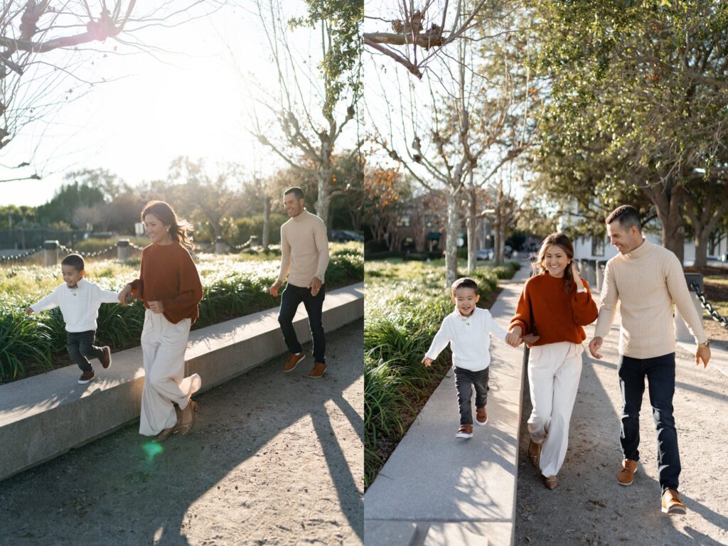 A family of three runs and plays together in a sunlit park during a family photo session with photographer Charleston SC. The young boy laughs joyfully while his parents follow closely, capturing candid moments full of movement, light, and connection in downtown Charleston.