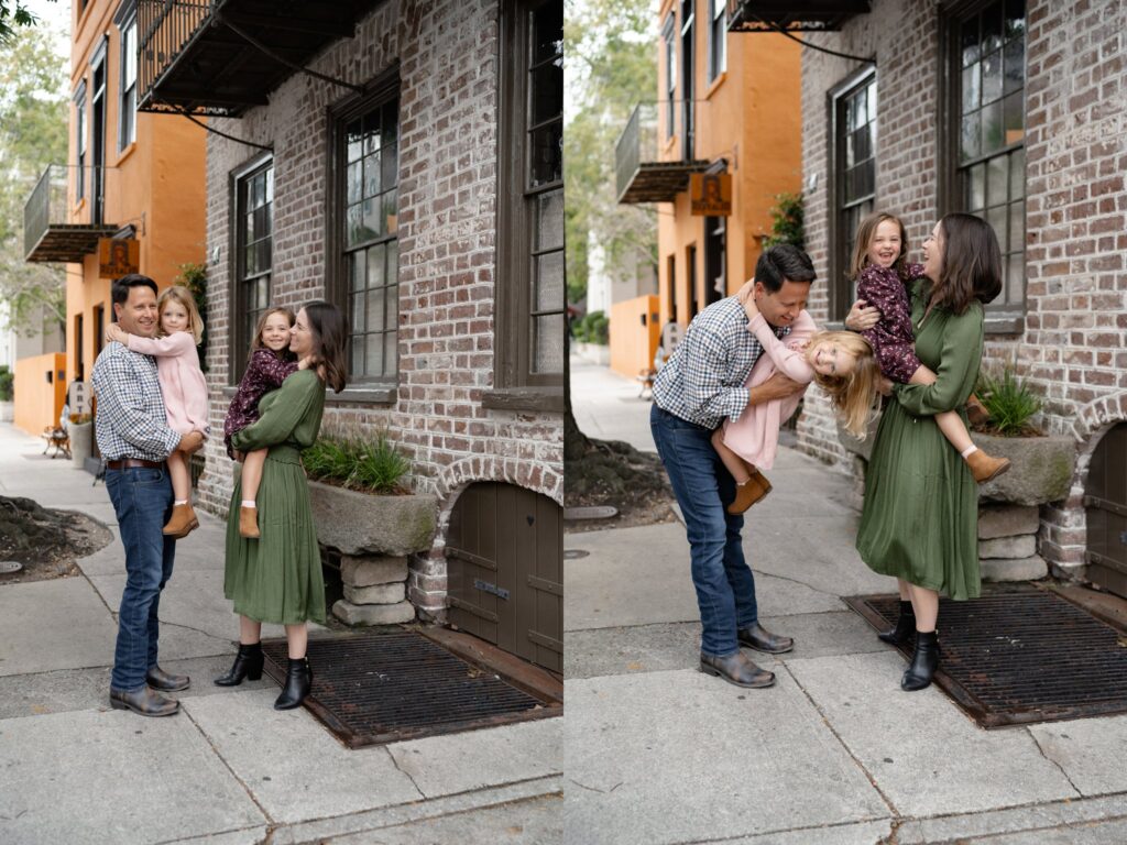 A family of four enjoys their mini sessions in Charleston, SC, standing by a brick and orange building. Parents each hold a daughter, and in the next photo, Mom playfully swings one daughter upside down as everyone smiles.